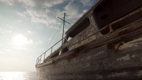 close-up-of-abandoned-old-shipwreck-,-ship-ruin-calm-sea-at-back-and-sunny-sky-,-memories-from-the-past