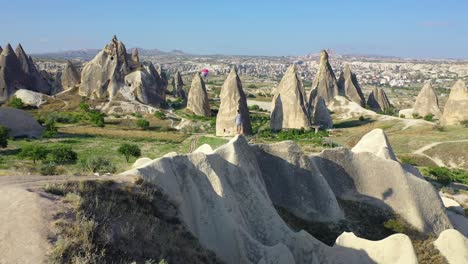 Male-traveler-taking-in-view-of-Cappadocia-landscape,-pull-back-aerial