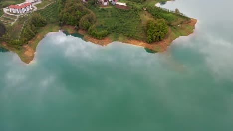 An-aerial-shot-above-Rama-Lake-along-the-coastline-showing-houses-and-natural-landscapes