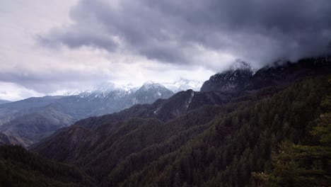 time-lapse-dark-clouds-top-of-mountain-forest-covered-in-snow-,-moody-scenery-spooky-shot