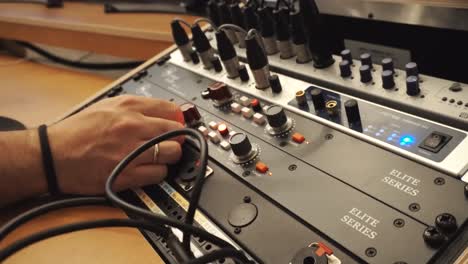 Cinematic-close-up-of-man-hands-adjusting-knob-levels-in-recording-studio