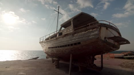 shipwreck-beached-on-sand-near-sea-sunny-day-,-old-ship-ruins-abandoned-vintage-boat-old-memories