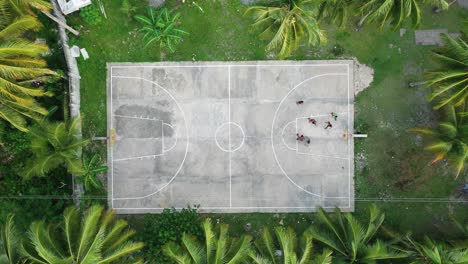 Menschen,-Die-Basketball-Auf-Dem-Platz-Zwischen-Palmen-Auf-Der-Tropischen-Insel-Siargao,-Philippinen,-Statische-Hochwinkel-luftaufnahme-Plattieren