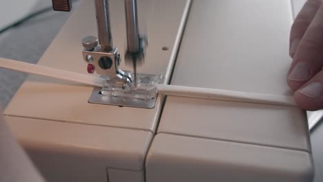 A-close-up-view-of-a-needle-on-a-sewing-machine-quickly-stitching-a-band-for-a-face-mask