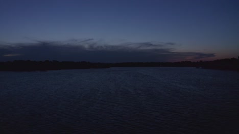 Low-rising-aerial-dolly-shot-across-lake-at-twilight