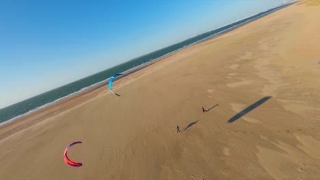 Aerial-flight-above-people-flying-kites-in-the-wind-at-golden-beach