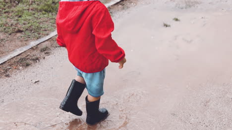 Kid-walking-in-slow-motion-in-a-muddy-puddle-at-the-park