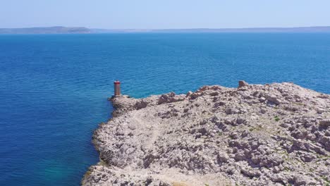 Aerial-flyover-towards-beacon-tower-on-rocky-point-in-Adriatic-Sea