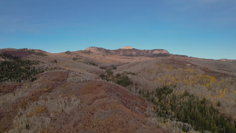 Fliegen-über-Hügel-Im-Herbstlaub-Gegen-Den-Klaren-Blauen-Himmel-In-Utah,-Usa