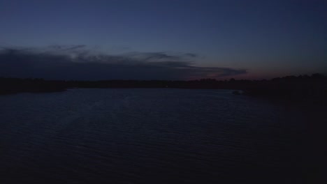 Rising-aerial-wide-shot-of-a-Midwestern-lake-during-twilight