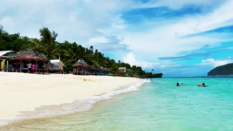 Hermosa-Vista-De-La-Vibrante-Playa-Tropical-De-Lalomanu-En-La-Isla-De-Samoa-Con-Gente-Nadando