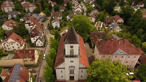 Flight-over-a-small-church-in-a-suburb,-Freiburg,-Zähringen