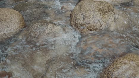 Small-river-full-of-rocks-in-a-beautiful-place-in-slow-motion,-very-detailed,-warm-color