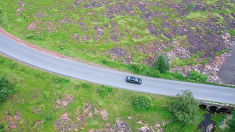 Aerial-View-Of-Cars-Driving-On-The-Road-Between-The-Green-Landscape