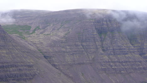 Towering-foggy-mountain-scape,-Westfjords-Iceland,-pan-right