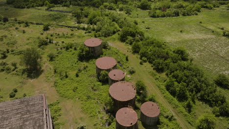 Rusty-Round-Tanks-On-Green-Field-Outside-An-Industrial-Chemical-Factory-In-Khashuri,-Georgia