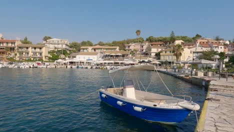 Panning-shot-of-Kassiopi-bay,-waterfront-picturesque-town,-Small-boats-moored,-Corfu-Island,-Greece