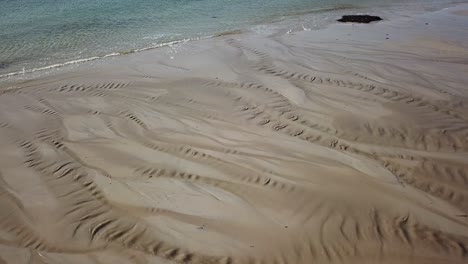 Blick-Auf-Spuren-Im-Sand-Aufgrund-Von-Flüssen,-Die-An-Einem-Irischen-Strand-Fließen