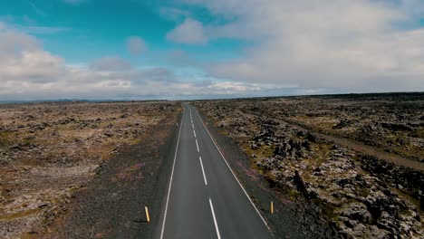 Flying-over-asphalt-road-and-mossy-lava-fields