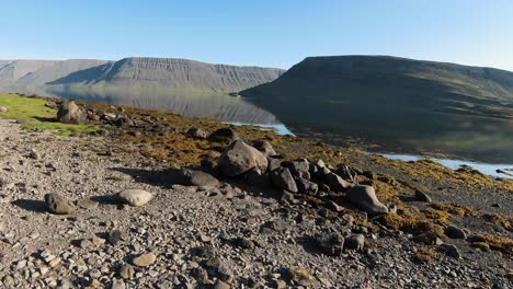 Westfjords-scenery-with-girl-on-stone-and-calm-lake