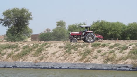 Roter-Traktor,-Der-An-Land-In-Punjab,-Pakistan-Umkehrt