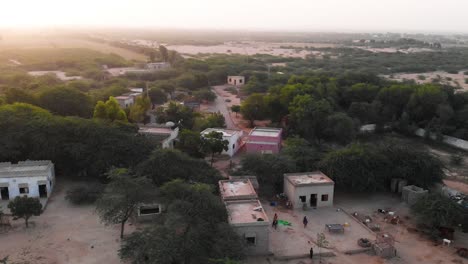 Luftbahnaufnahme-Des-Ländlichen-Dorfes-In-Sindh-Mit-Sonnenuntergang-Am-Horizont