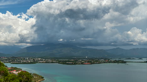 The-Ouemo-suburb-of-Noumea-with-Mount-Koghi-in-the-background-and-a-dynamic-cloudscape-above---time-lapse