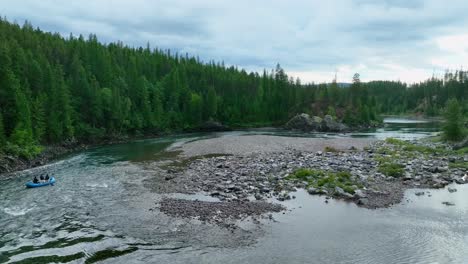 Rafters-On-Flowing-River-With-Stony-Riverbed-Surrounded-By-Evergreen-Forest-In-Montana,-USA