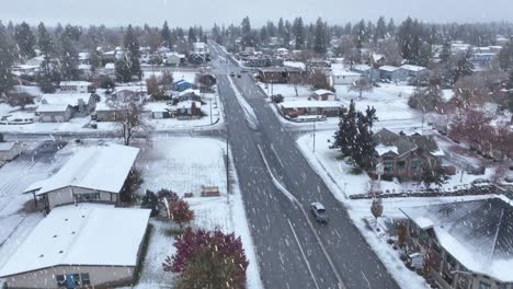 Aerial-view-of-a-truck-driving-through-snow-in-a-suburban-neighborhood