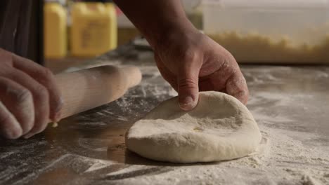 Preparation-of-the-dough-for-pie,-chef-rolling-dough-using-roll-and-flour