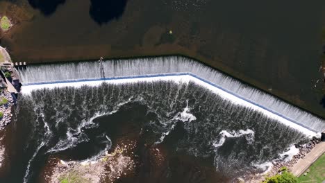 Top-down-aerial-of-dam-on-river-waterfall-in-USA-city