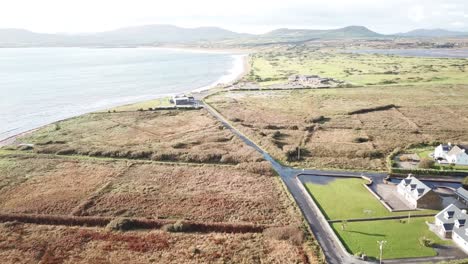 aerial-view-of-the-countryside-in-Connemara,-Ireland,-ocean-shore-and-meadows