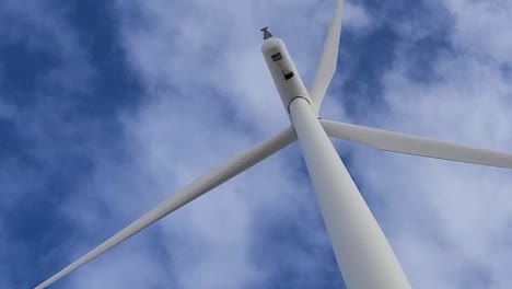 Driving-under-spinning-wind-turbine-blade,-close-up