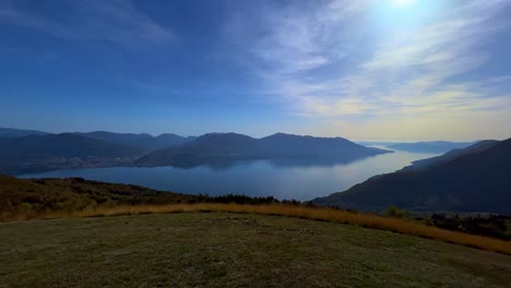 Panoramic-panning-scene-of-Lake-Maggiore-seen-from-Monte-Carza-mountaintop-viewpoint,-zoom-in