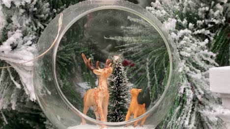Süßer-Hirsch-Auf-Einem-Weihnachtsbaum-Mit-Viel-Schnee-Mitten-In-Einer-Blase
