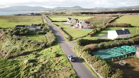 Ireland,-Connemara,-a-car-drives-on-a-road-near-fields,-europe-landscape