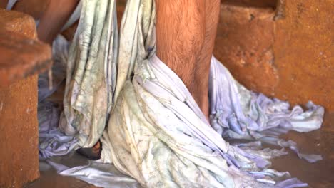 Ein-Mann-Mit-Lederstücken-Um-Die-Beine-In-Einer-Gerberei-In-Fès,-Marokko