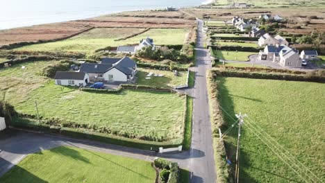 aerial-view-of-a-small-cottage-in-Connemara,-Ireland,-a-road-crosses-the-village
