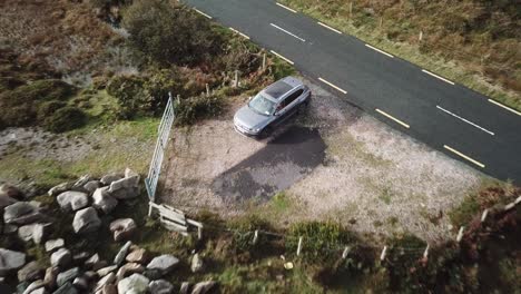 aerial-view-of-a-car-parked-on-the-side-of-a-road-in-Connemara,-Ireland