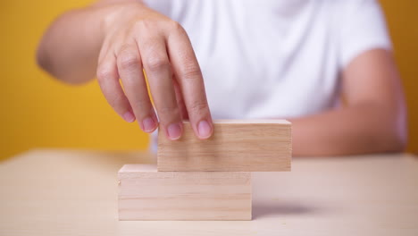 Hand-putting-wood-cubes-on-top-of-wood-block-stacking-as-step-stair-business-growth-to-success-but-it-failed