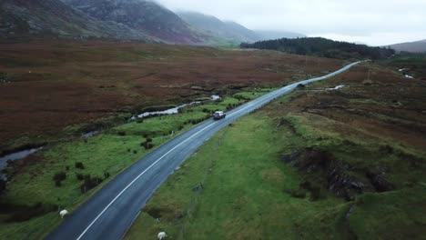 Aerial-view,-two-cars-pass-each-other-on-a-road-in-Connemara,-Ireland
