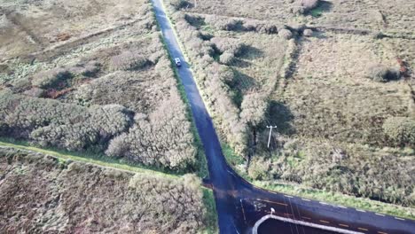 aerial-top-view-of-a-road-in-Connemara,-ireland,-car-driving