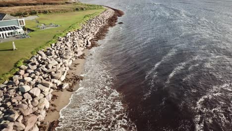 aerial-view-of-a-rocky-shore-in-Connemara,-Ireland,-waves-crash
