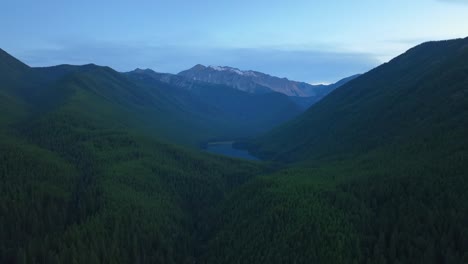 Luftaufnahme-Des-Stanton-Lake,-Umgeben-Von-Bewaldeten-Und-Schneebedeckten-Bergen-An-Einem-Kalten-Morgen-Im-Great-Bear-Wilderness-Area,-Flathead-National-Forest,-Montana,-USA