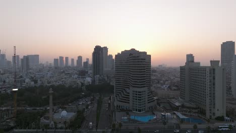 Tel-Aviv-coastline-at-sunrise-with-beautiful-calm-waters-of-The-Mediterranean-Sea,-Waterfront-hotels-and-light-sun-flare