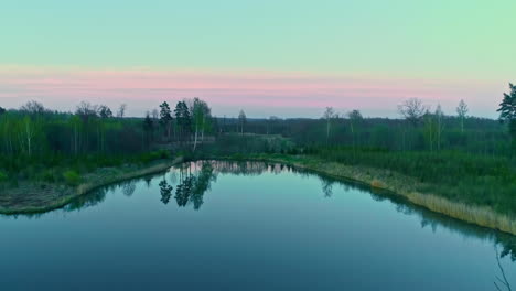 -Top-down-aerial-shot-of-reflection-of-blue-sky-on-large-lake-during-evening-time-after-sunset