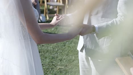 Bride-and-groom-holding-hands-saying-wedding-vows