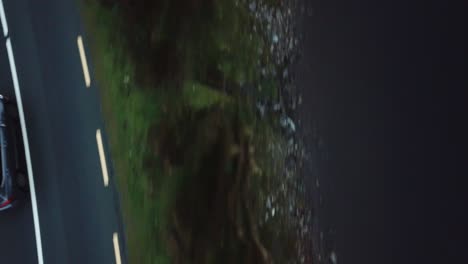 top-view-of-a-car-driving-near-the-ocean-in-Connemara,-Ireland