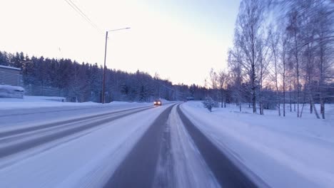 POV-shot-driving-along-a-snowy-road-with-clean-tracks-made