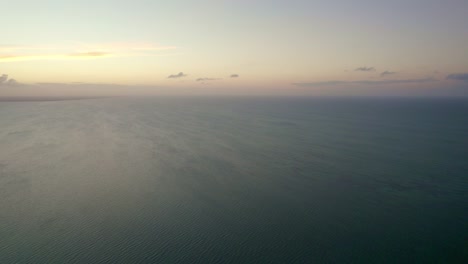 Aerial-shot-of-a-vibrant-sunset-setting-over-the-ocean